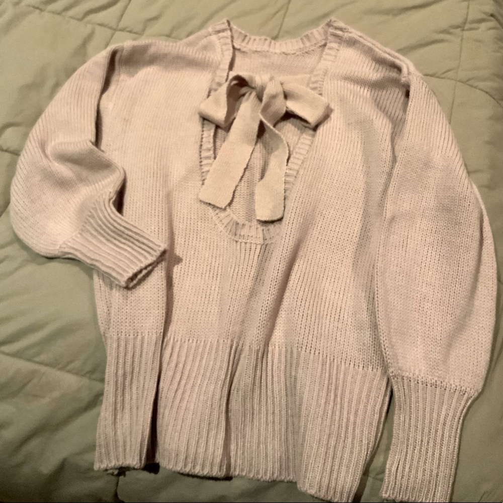 Blush colored women’s sweater with open back
